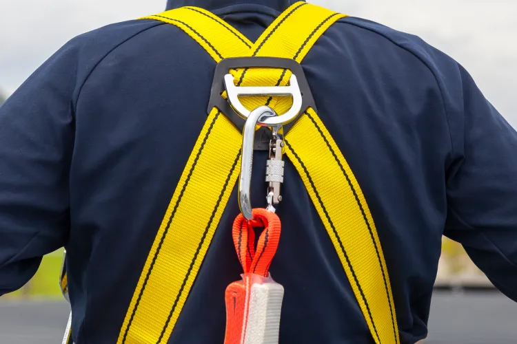 A rope access Window Cleaner wearing a safety harness