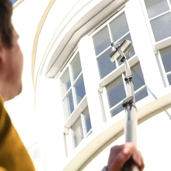 A window cleaner using a pure-water pole system to wash a hotel's windows