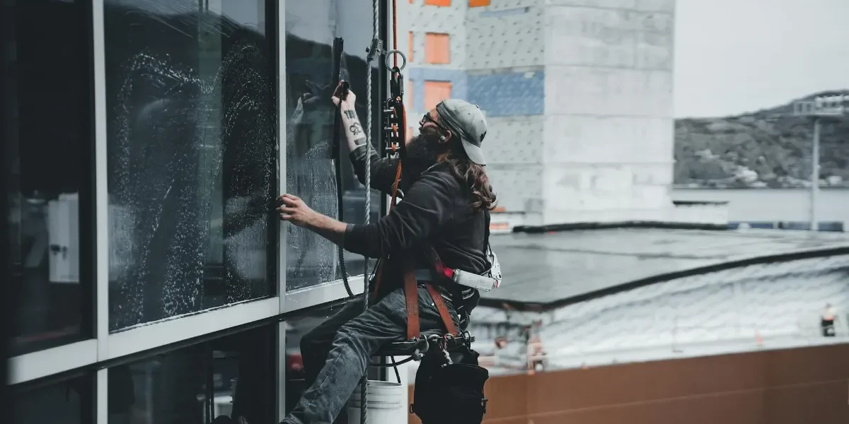 A Window Cleaner using rope access to clean a high-rise building