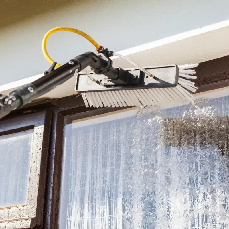 a water-fed window cleaning pole spraying pure water on a window