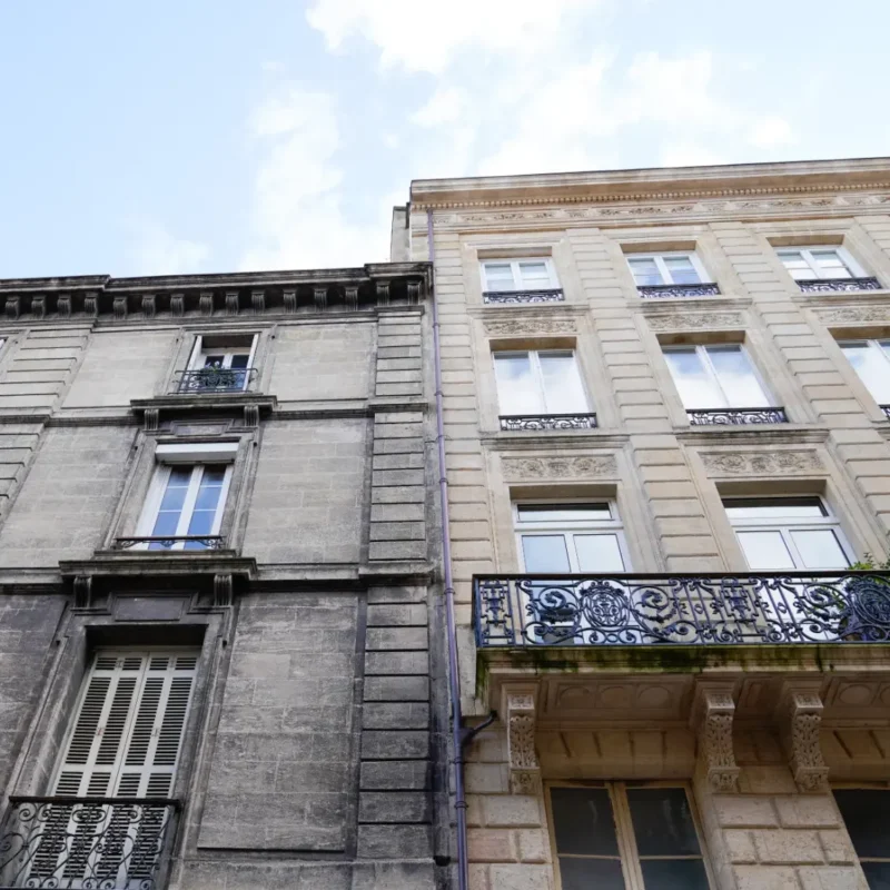 a building with a clean exterior facade next to a dirty building