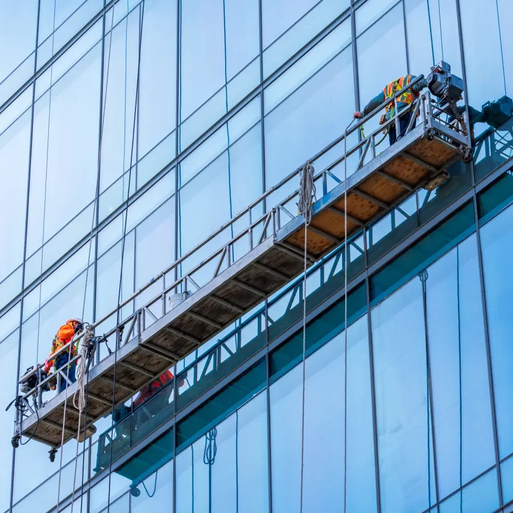 professional window cleaners on a BMU Cradle platform cleaning the glass exterior of a hotel.