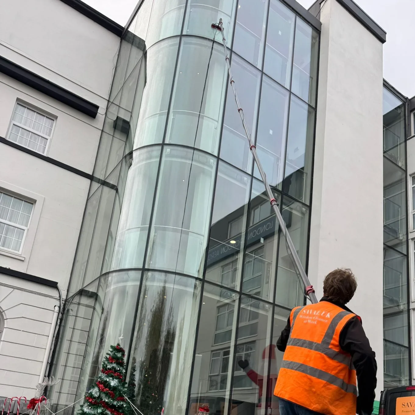 Saval UK window cleaners cleaning ground-level glass at a London hotel entrance