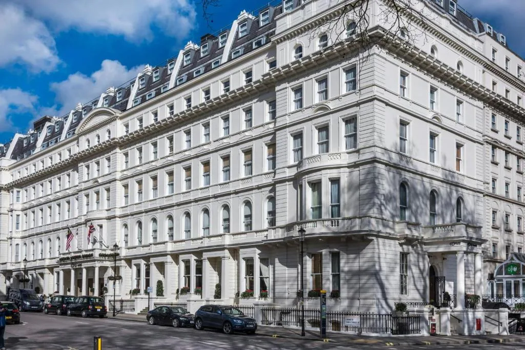 The long white Victorian frontage at 1 Lancaster Gate, with balconies, cornices and rows of tall windows under a blue sky.